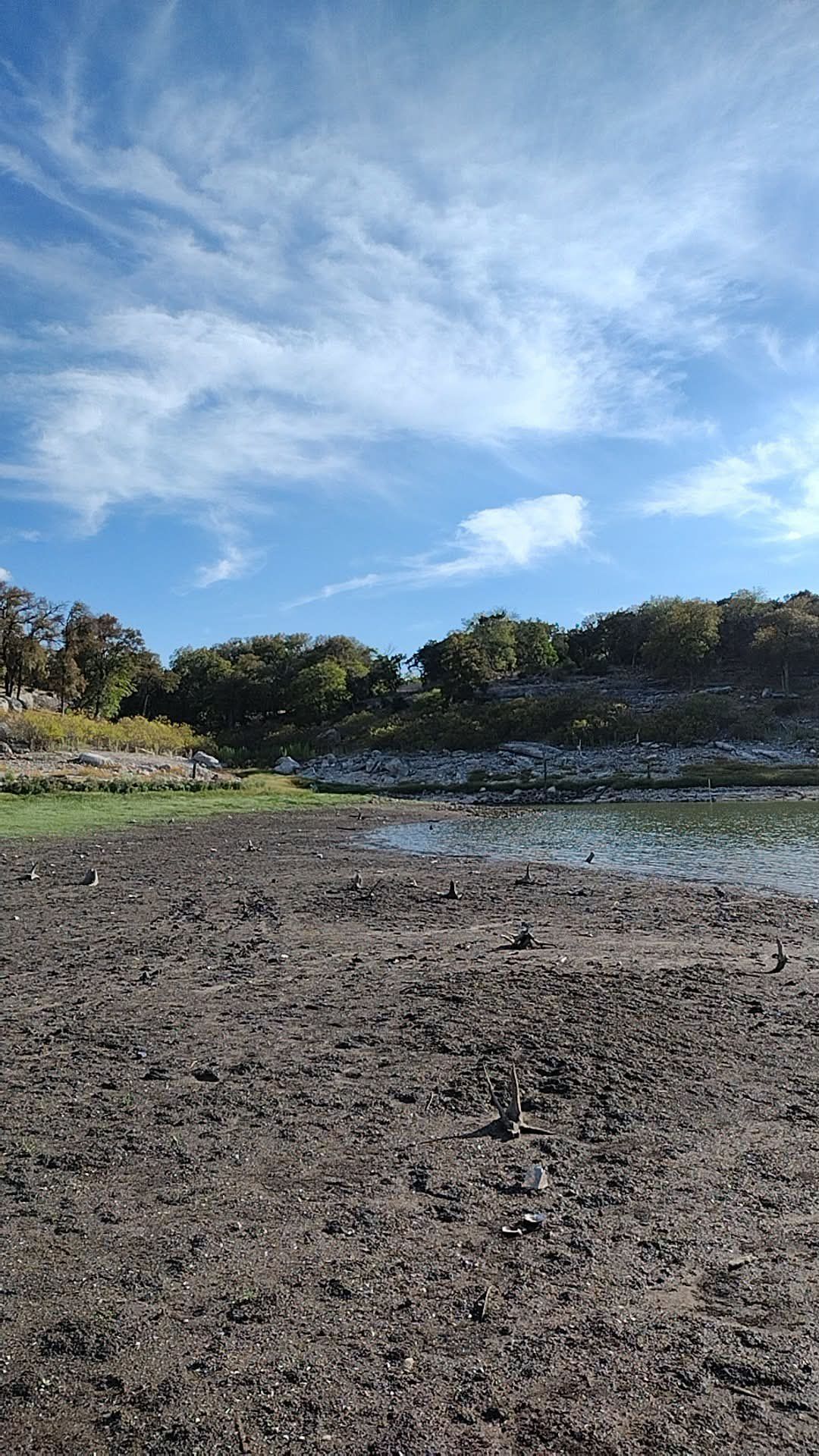 Dry, cracked shoreline at Lake Belton with the water line far from the bank